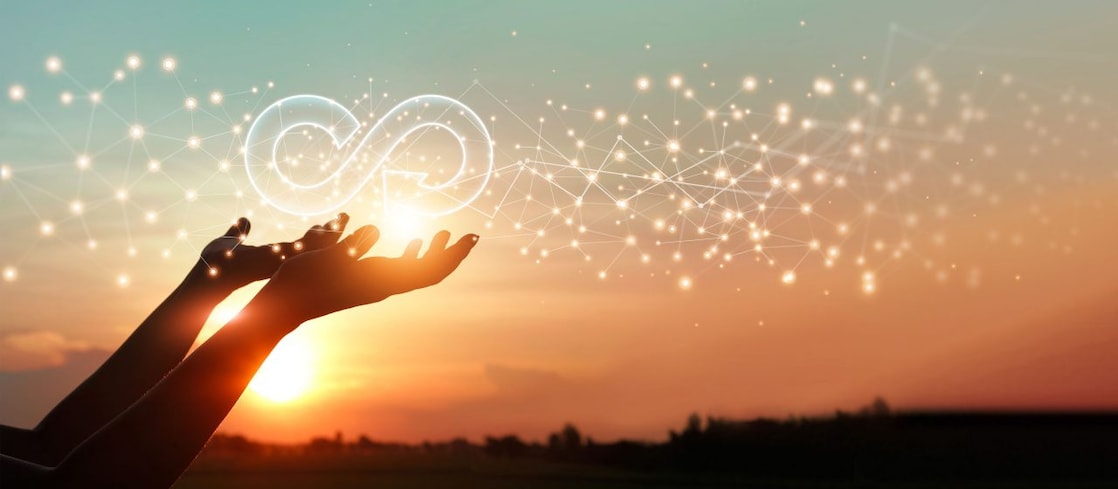 Open palms against a sunset with an overlayed recycle symbol hovering above the hands