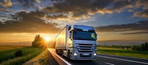 Freight truck against a beautiful sunset on a highway through countryside